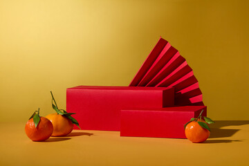 Two red podiums in rectangle shaped displayed with some tangerines and a paper fan. Collection of...