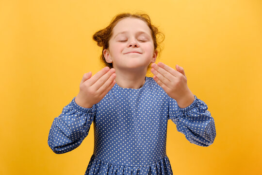Portrait of happy preteen girl stretching relaxing, smiling preteen child with eyes closed feel peaceful breathing fresh air, good pleasant smell, posing isolated on yellow background wall in studio - Powered by Adobe