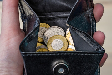 Polskie monety trzymane w dłoni w portfelu, 5ł, 2zł i 1zł