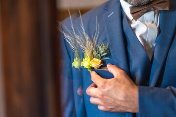 Detail of the groom's suit at the wedding, placing some beautiful flowers in the pocket