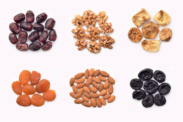 Dried fruits, fresh dates and nuts isolated on the white background. Healthy food concept. Top view.