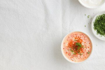 Red caviar with sour cream, dill and onion - the finnish recipe for a holiday food, flat lay on the white table in minimalistic style with copy space