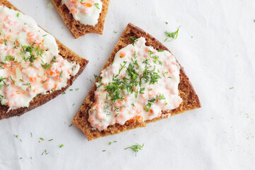 Appetizer with red caviar, sour cream, dill, onion and rye bread on the white table - the finnish recipe for a holiday food, flat lay in minimalistic style