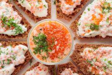 Appetizer with red caviar, sour cream, dill, onion and rye bread on the white table - the finnish recipe for a holiday food, flat lay in minimalistic style