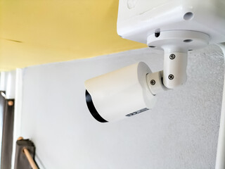 Installation of white CCTV cameras on the ceiling inside the building.