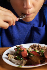 eats buckwheat porridge with vegetable salad