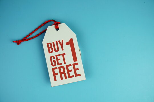 Top view of Buy one get one free text on tag sale flat lay on blue background