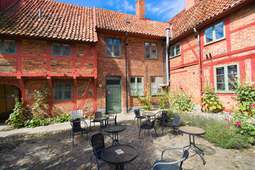 Lovely courtyard of half-timbered building of Helsa Farm in Ystad, Sweden - 699516378