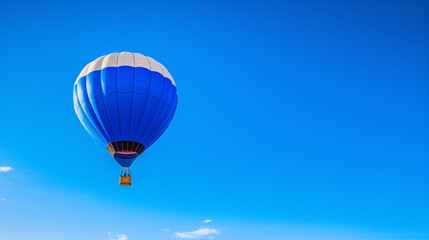 Naklejka premium Colored hot air balloon on a clear blue sky with few clouds 