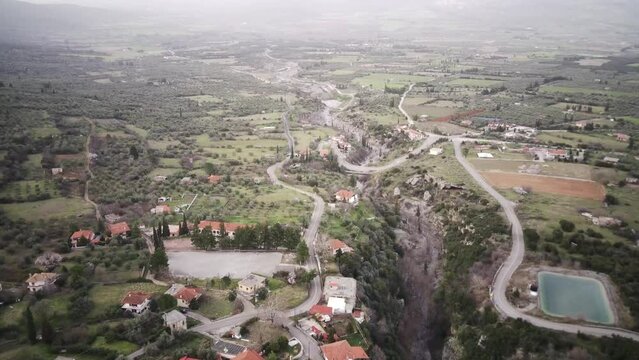 Aerial footage of the buildings and green fields in Tithorea municipality on Velitsa gorge, Greece