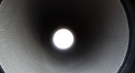 Looking through long round concrete pipe