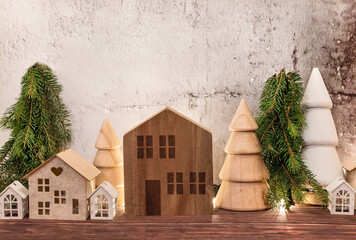 Christmas decoration with wooden small houses in Scandinavian style and Wooden Pine trees