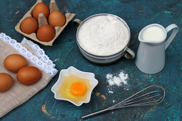 Backzutaten Mehl, Eier, Milch mit Backutensilien. 