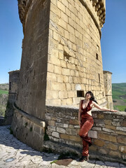 Glamour in Rocchetta Sant'Antonio: A young woman, donning daring and revealing attire, injects vitality into the stillness of the Rocca, breaking the monotony of timeless moments.