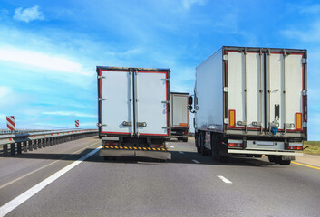 Trucks with containers move along a country highway