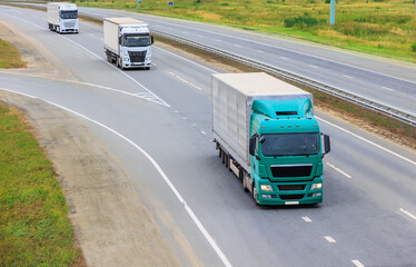 Three trucks moving along  highway