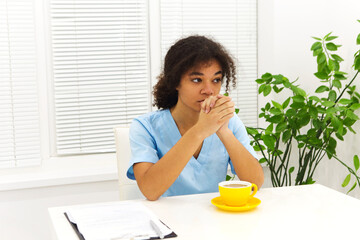 Tired depressed african american woman doctor or nurse in uniform suffer from headache after hard working day