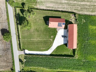 Działka z domem i garażem z lotu ptaka. Trawnik i ogrodzona Działaka z domem
