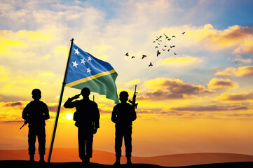 Silhouettes of soldiers with the Solomon Islands flag stand against the background of a sunset or sunrise. Concept of national holidays. Commemoration Day.