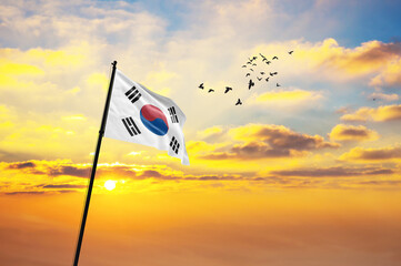 Silhouette of a soldier with the South Korea flag stands against the background of a sunset or...