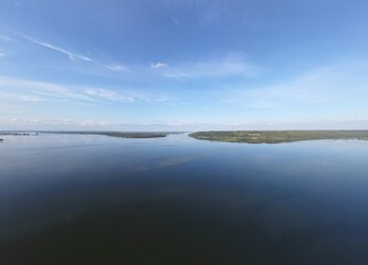 There is a thin strip of land on the horizon. There is water all around. America.