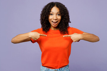 Little surprised amazed kid teen girl of African American ethnicity she wear orange t-shirt point...