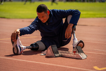 Asian para-athlete runner prosthetic leg on the track training alone outside on a stadium track...