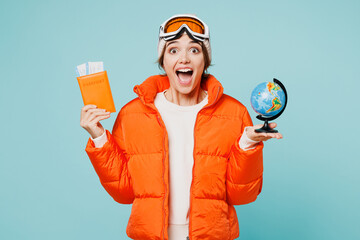 Traveler skier woman wearing padded windbreaker jacket ski goggles mask hold passport ticket...