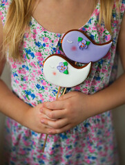 little girl holding violet and white cookies with the birds