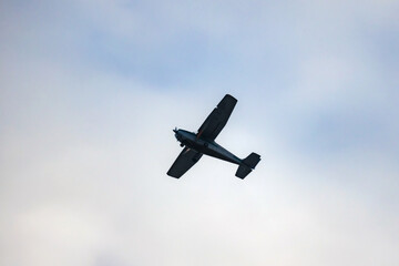 Light aircraft silhouette is in cloudy sky