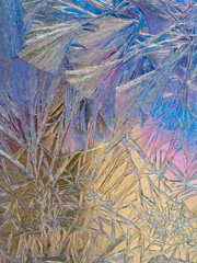 Beautiful ice pattern and sunlight close up on window glass early in the morning, natural winter background