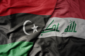 big waving national colorful flag of iraq and national flag of libya .