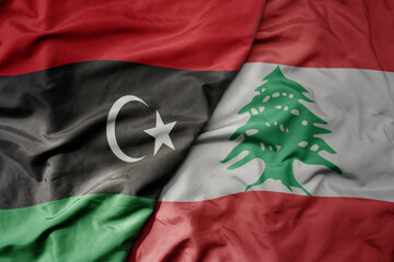 big waving national colorful flag of lebanon and national flag of libya .