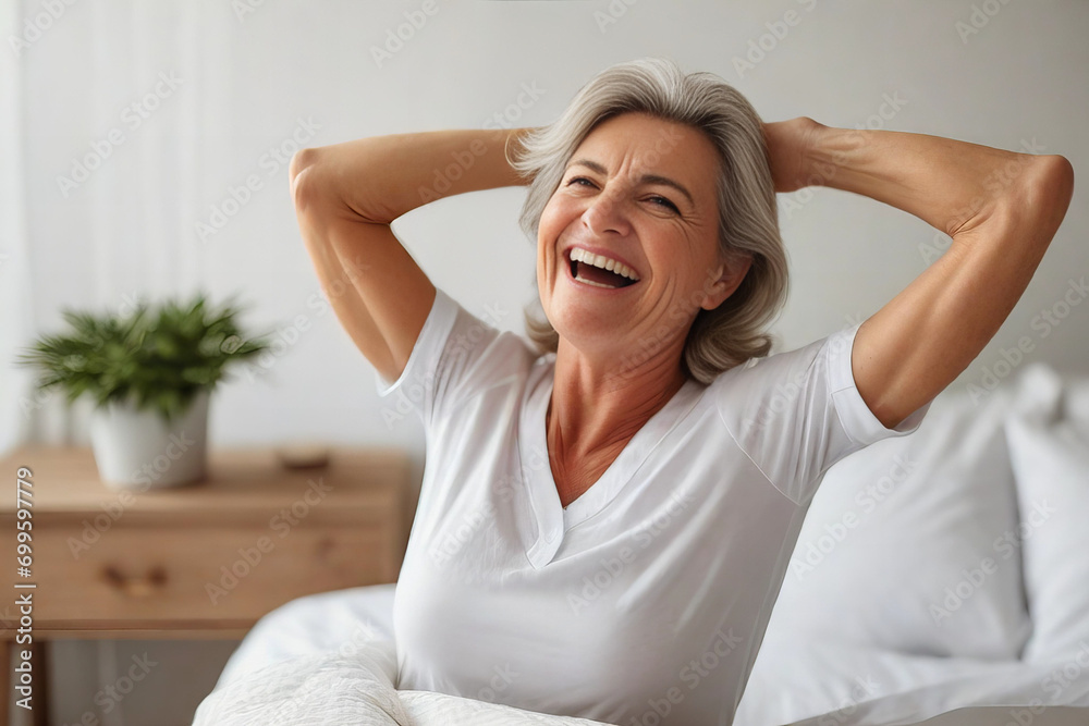 Wall mural happy mature woman in the morning in bed at home, good carefree morning