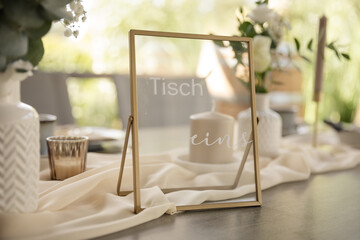 Tischnummer in gold auf einer eleganten Hochzeitstafel - 699607770