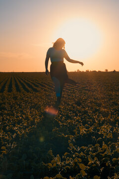 Chica caminando en el campo durante el atardecer