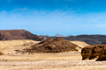 high rocky mountains against the blue sky and white clouds in the desert in Egypt Dahab South Sinai