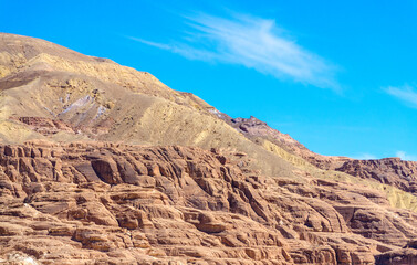 high rocky mountains against the blue sky and white clouds in the desert in Egypt Dahab South Sinai