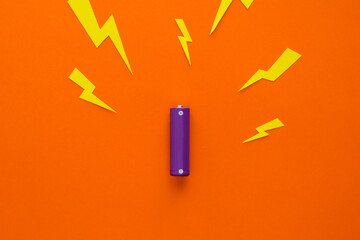 Battery and lightning bolts flying from it on an orange background