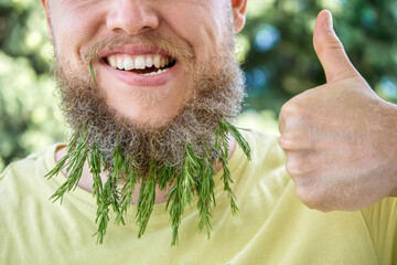 Smiling man beard and fragrant sprig of rosemary. Adult behaving childishly man in sunny meadow...