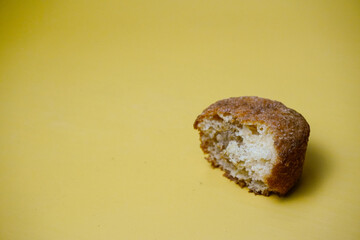 bitten slice of cupcake isolated on yellow background, side view