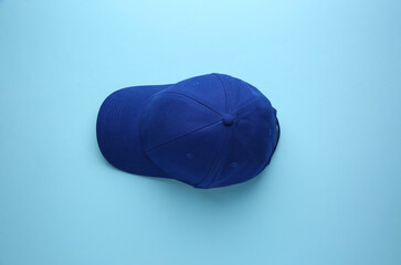 Stylish baseball cap on light blue background, top view