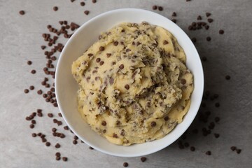 Chocolate chip cookie dough in bowl on gray table, top view