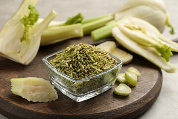 Fennel seeds in bowl and fresh vegetables on table, closeup
