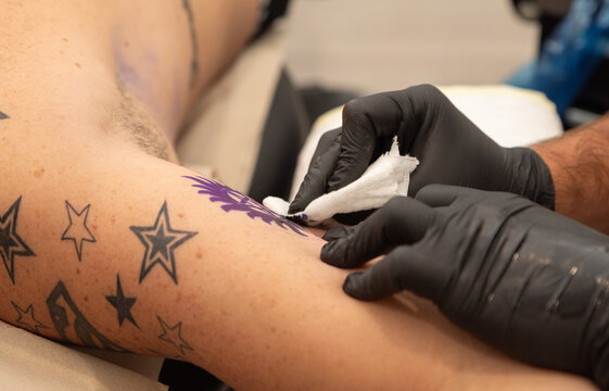 tattoo artist performing a tattoo on a client
