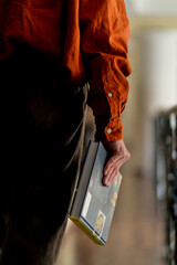 close-up back view male hand holding book in study library