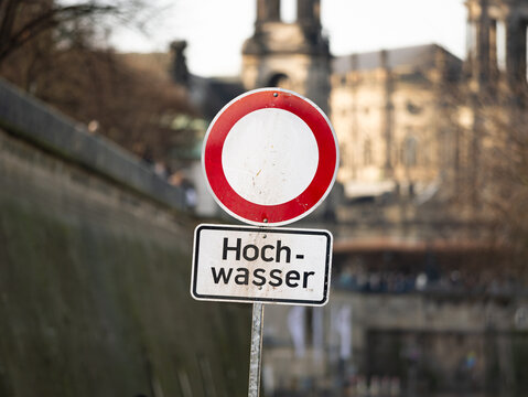 Hochwasser (floods) sign in the old town of Dresden during winter 2023. The Terrassenufer road is closed due to high water levels. A safety measure to protect the people. A traffic sign forbids access