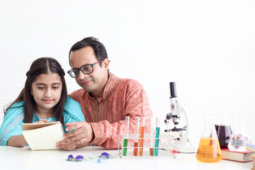 Cute Indian school girl in India traditional dress costume doing science experiments in laboratory...