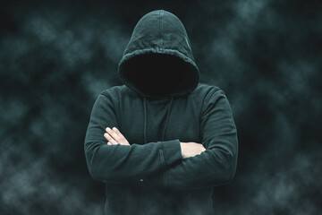 Mysterious faceless hooded anonymous criminal, silhouette of computer hacker, cyber terrorist or...