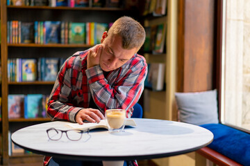 male student in the library who got an idea while reading a book against the background of...